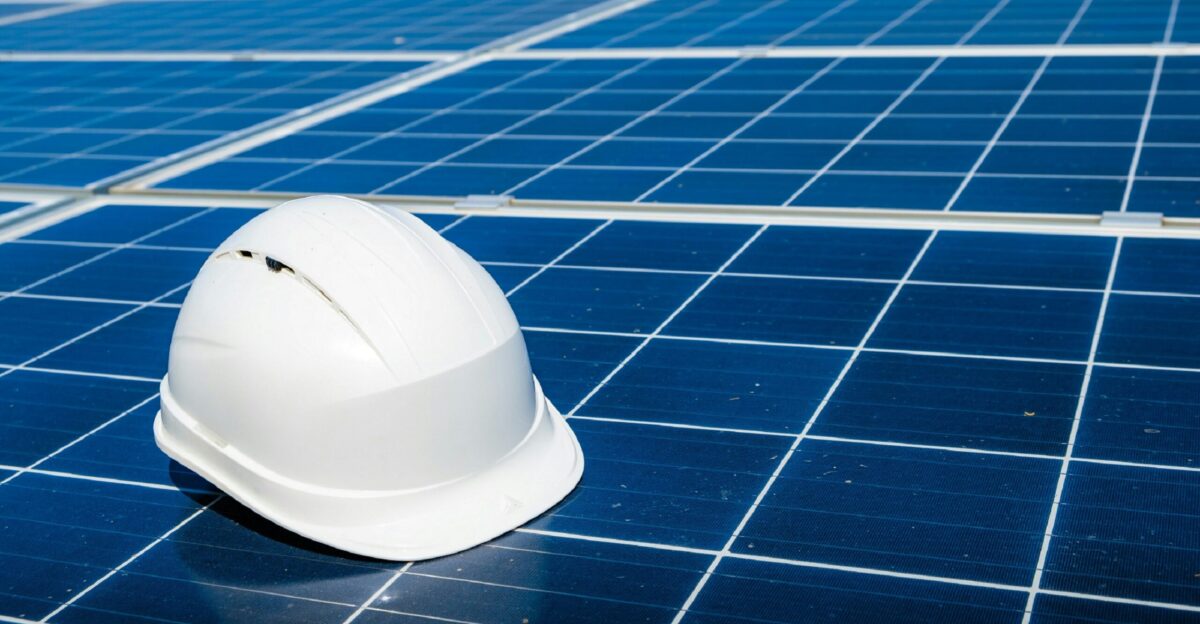 a white hard hat sitting on top of a solar panel