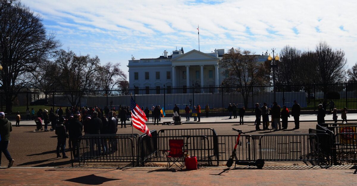 a group of people standing in front of a white house