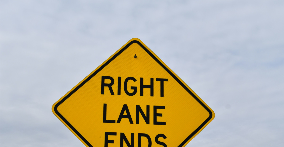 a yellow sign that says right lane ends