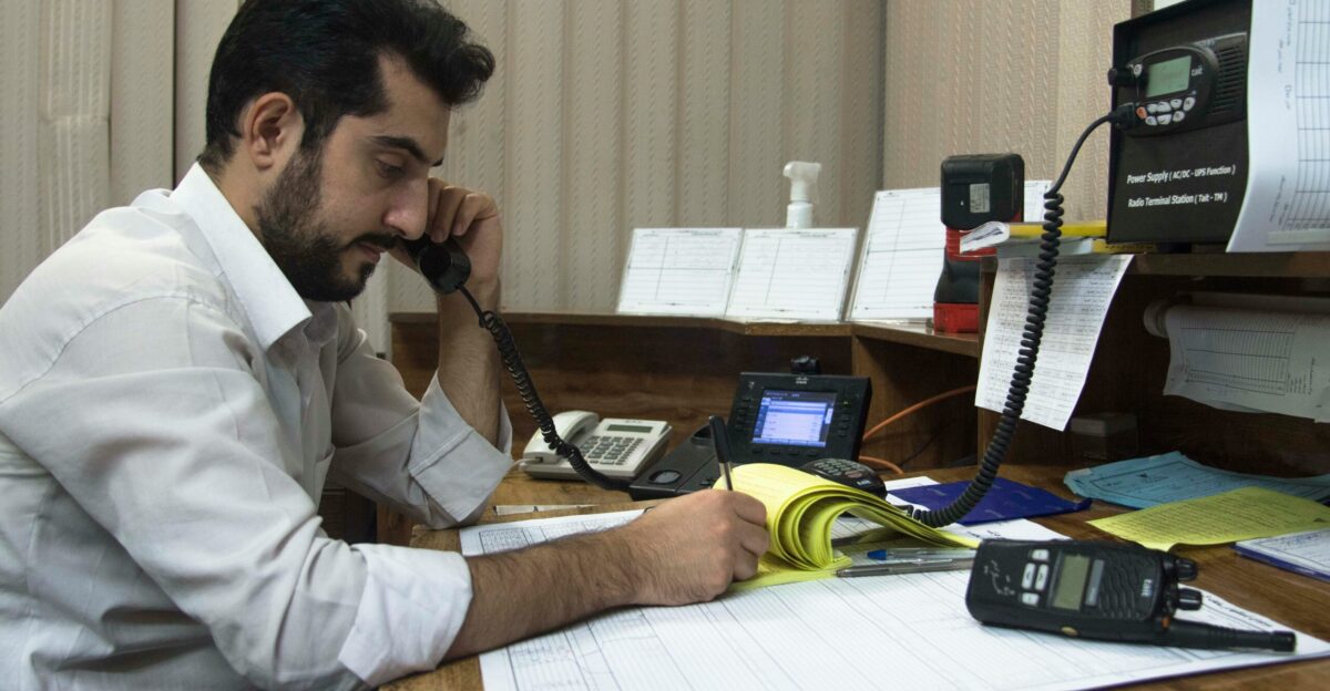 a man sitting at a desk talking on a phone