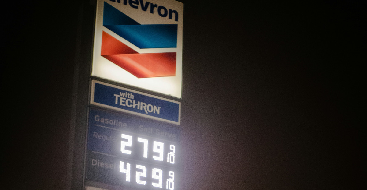 a chevron gas station sign lit up at night