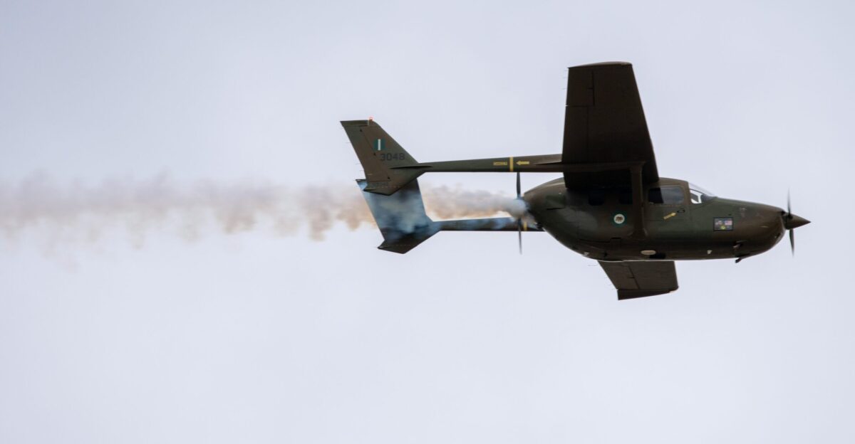 a plane with smoke coming out of it flying in the sky