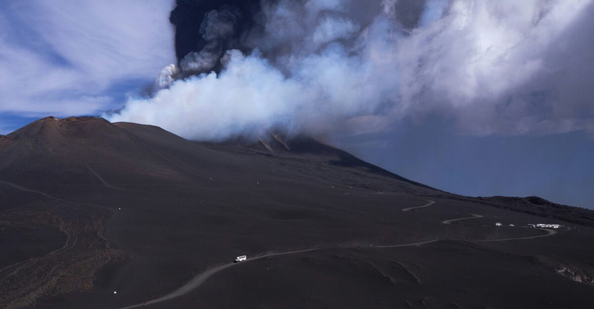 a large plume of smoke rising from a volcano
