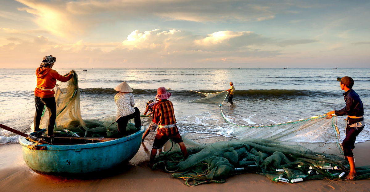 a group of people standing on top of a beach next to a boat