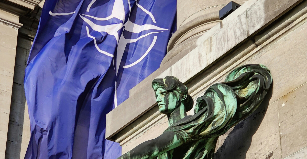a statue of a man holding a flag in front of a building