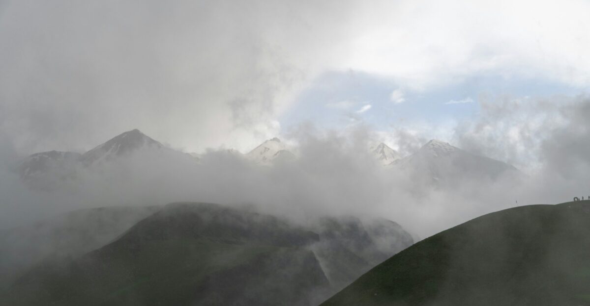a view of a mountain range covered in clouds