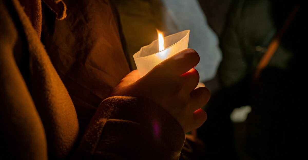 a person holding a lit candle in their hand
