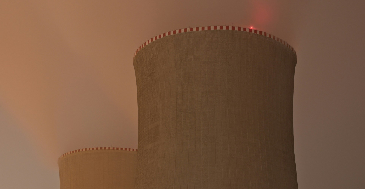 a nuclear power plant at night with a foggy sky