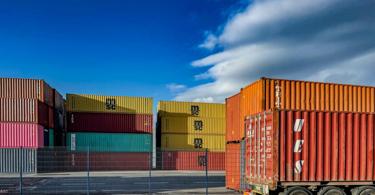 a truck is parked in front of a bunch of shipping containers