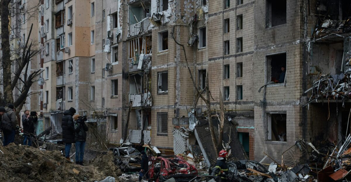 a group of people standing in front of a pile of rubble