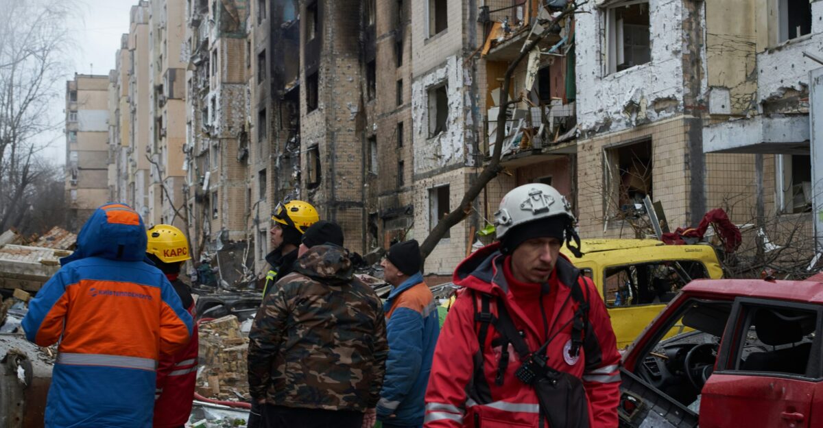 a group of people standing around a destroyed building