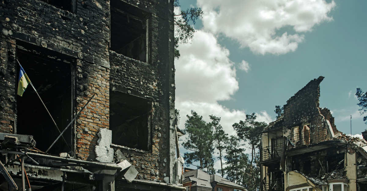 a man standing in front of a destroyed building