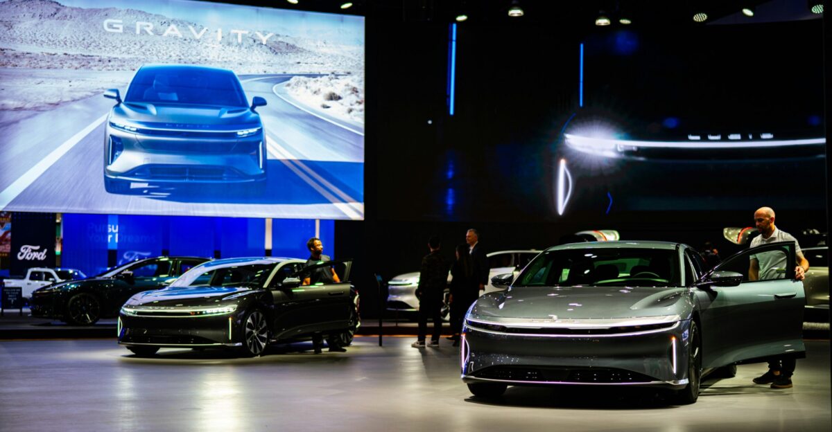 a group of people standing around a bunch of cars