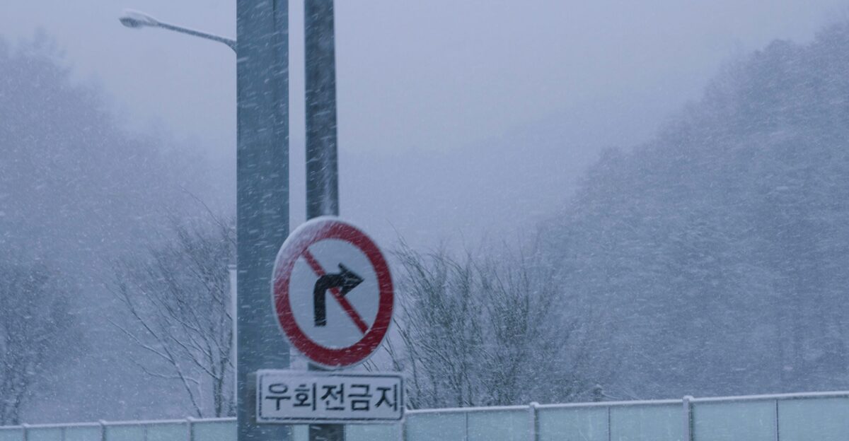 a street sign on a pole on a snowy day