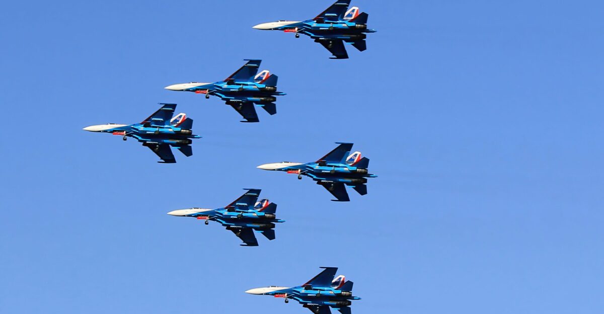 a formation of fighter jets flying through a blue sky