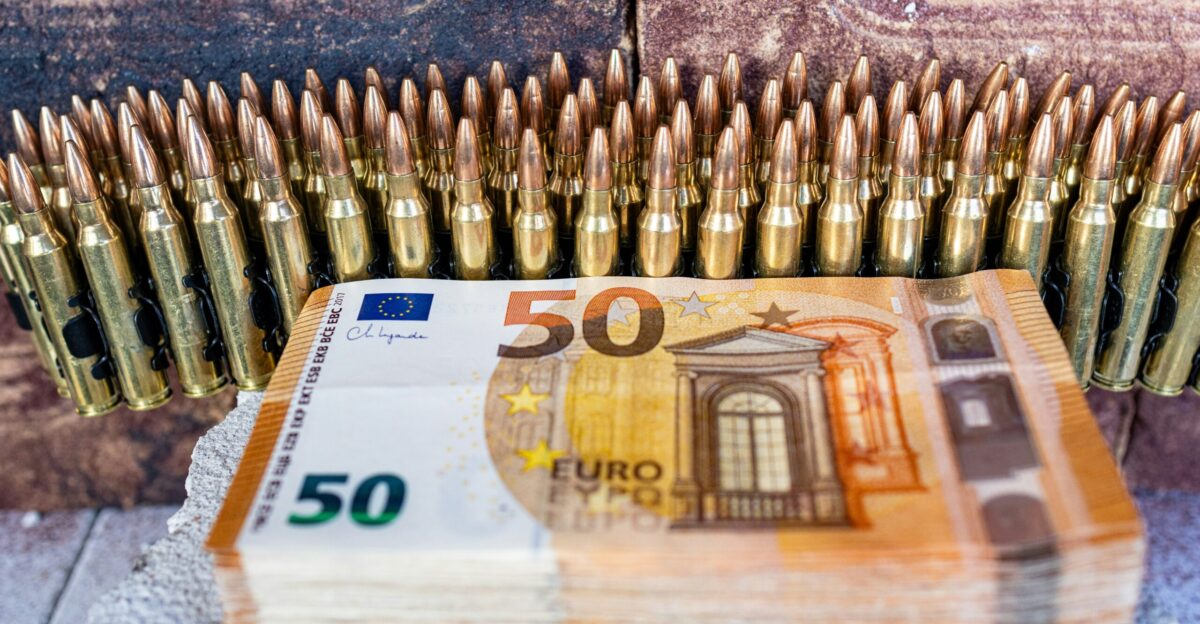 a bunch of bullet shells sitting on top of a pile of 50 euros bills