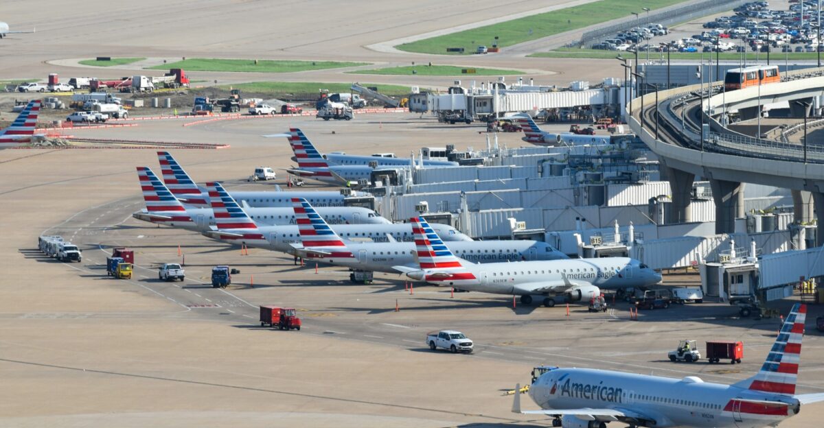 an airport filled with lots of airplanes parked on top of tarmac
