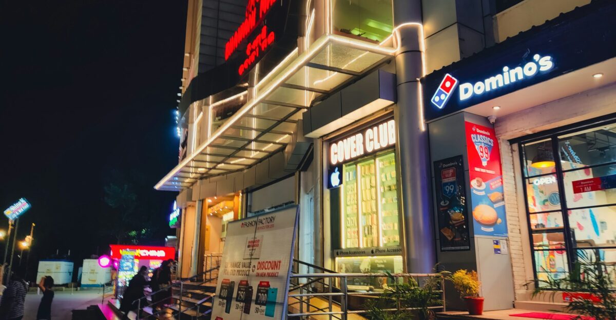 A group of people standing outside of a building at night