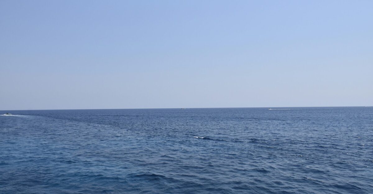 A large body of water with a boat in the distance