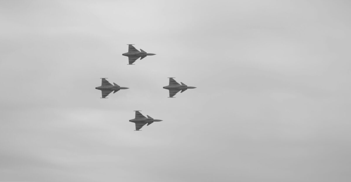 A group of fighter jets flying through a cloudy sky