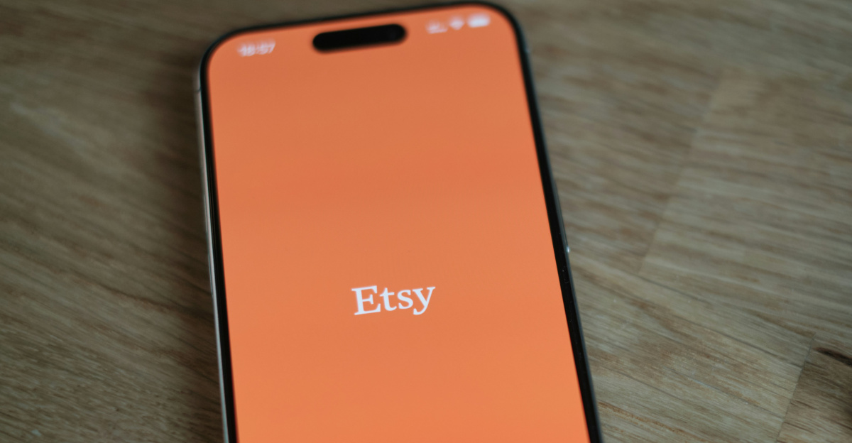 An orange cell phone sitting on top of a wooden table