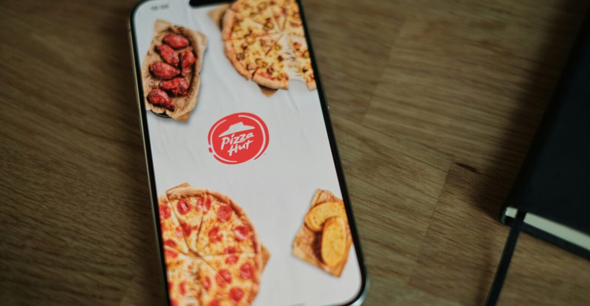 A pizza phone case sitting on top of a wooden table