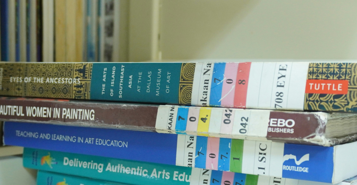 A stack of books sitting on top of a white shelf