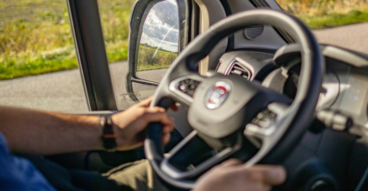 A man driving a car down a rural road