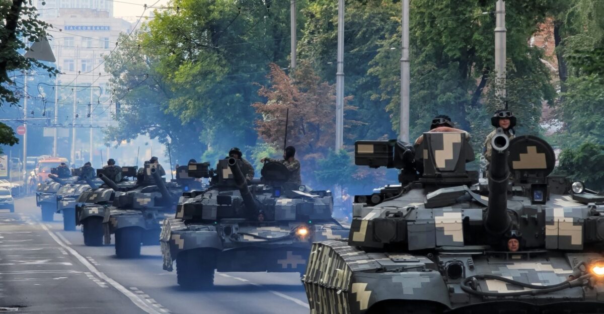A group of tanks driving down a street