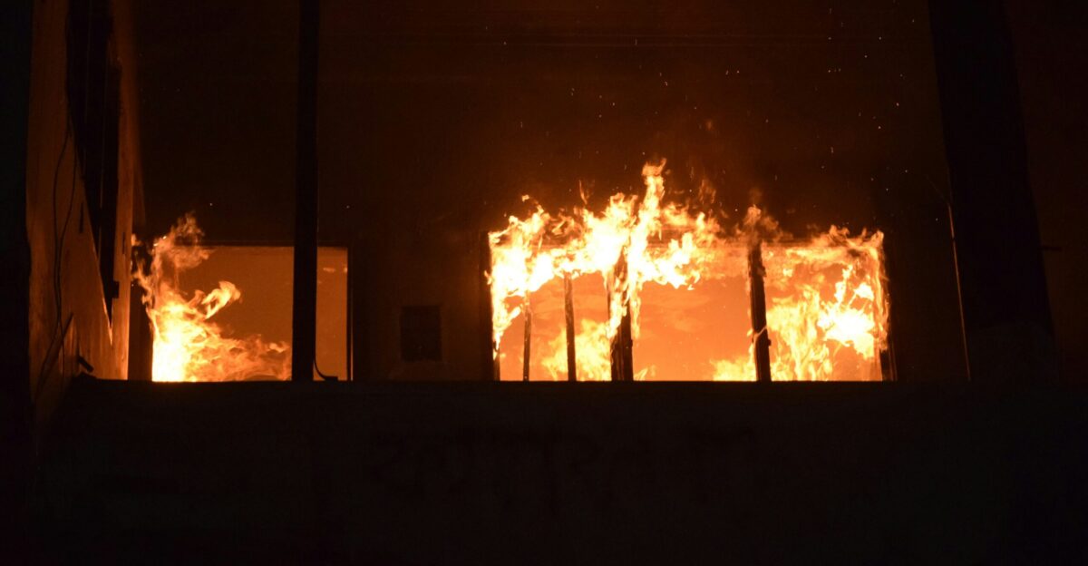 A fire is burning in a building at night