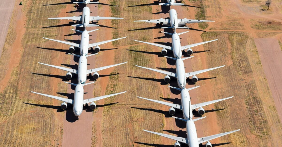 A large group of airplanes parked in a field
