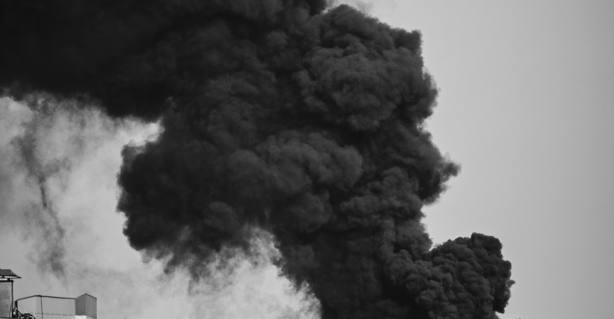 A massive plume of black smoke rises