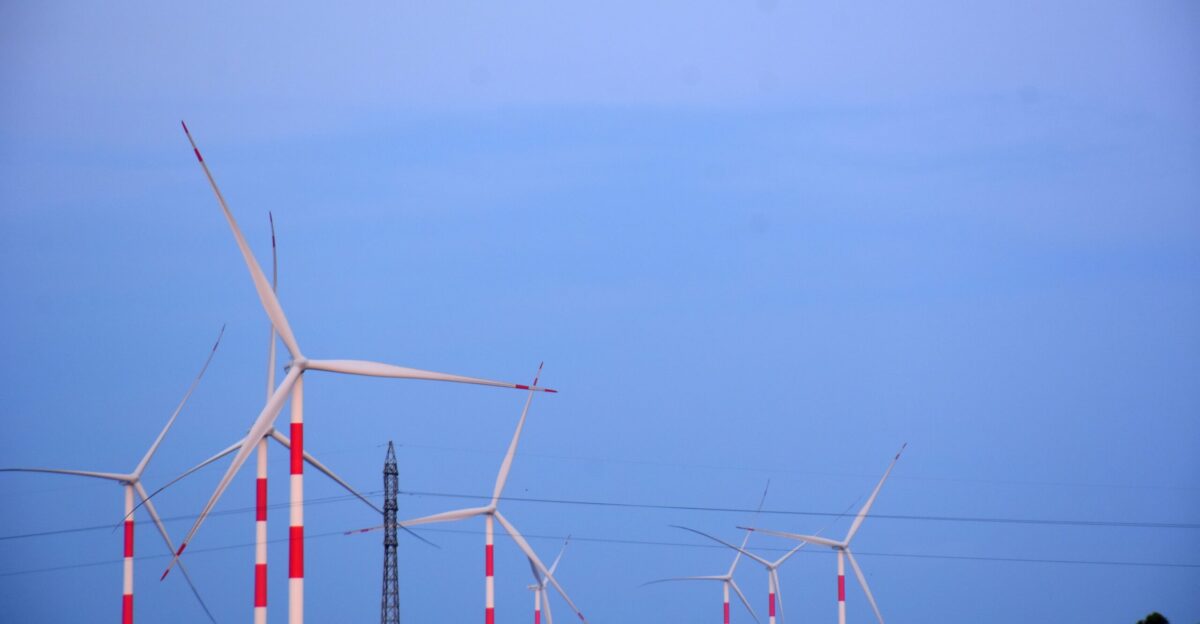 Wind turbines stand tall against a blue sky