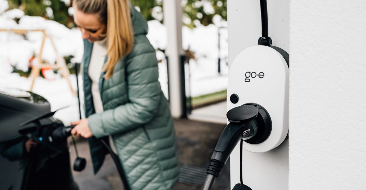Woman plugs in an electric car to charge