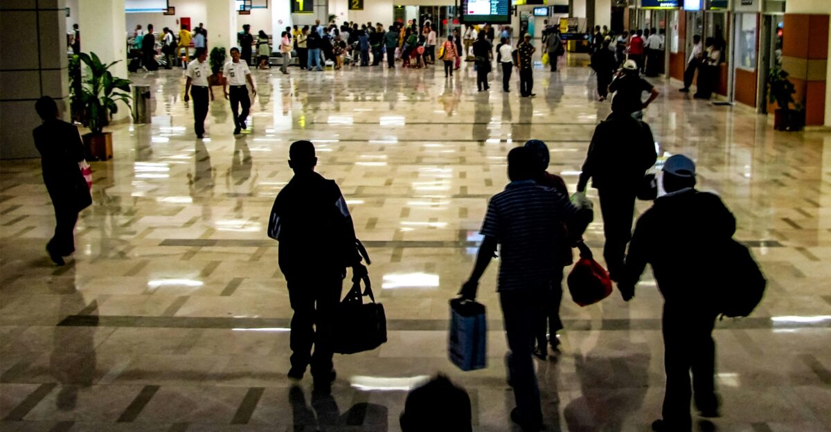 People are walking through a busy airport terminal