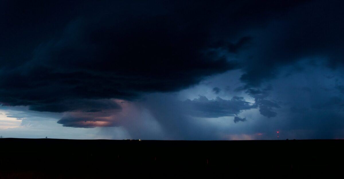 Dark storm clouds loom over a landscape