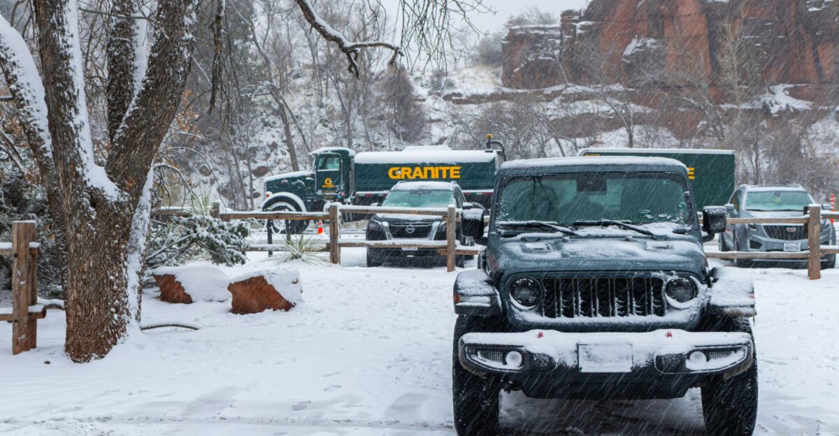 Jeep and trucks parked in snowy landscape