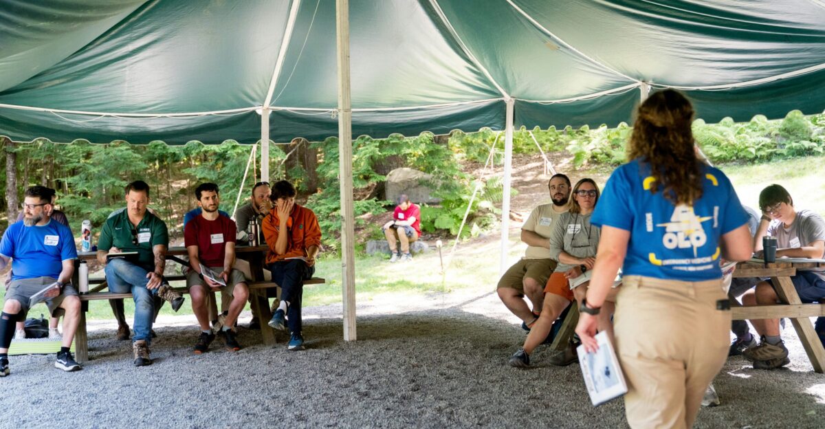Group listening to presenter under a tent