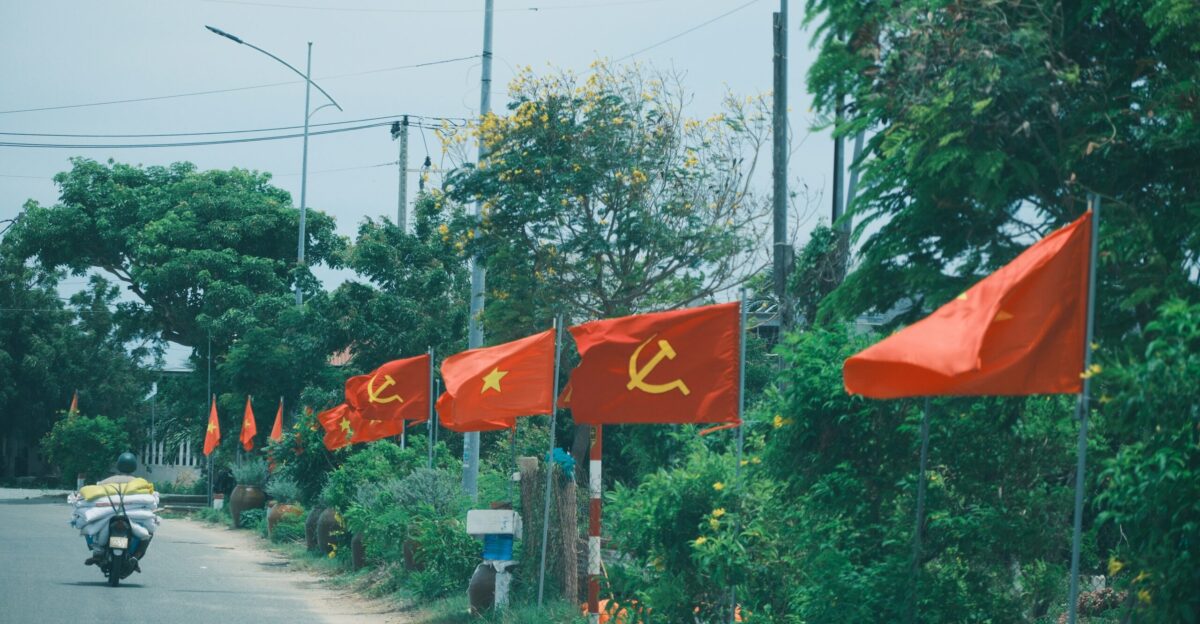 Red flags with hammer and sickle line a roadside