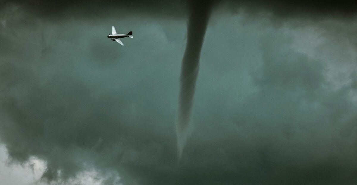 Small airplane flies near a powerful tornado
