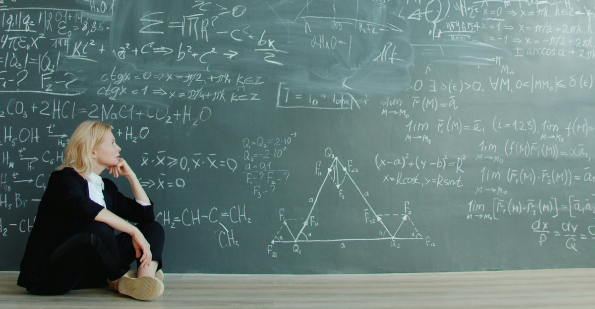 Woman contemplating complex formulas on a blackboard.