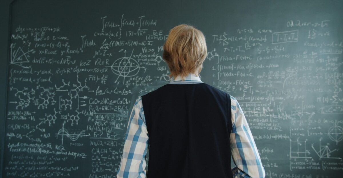 Student looking at complex mathematical formulas on blackboard