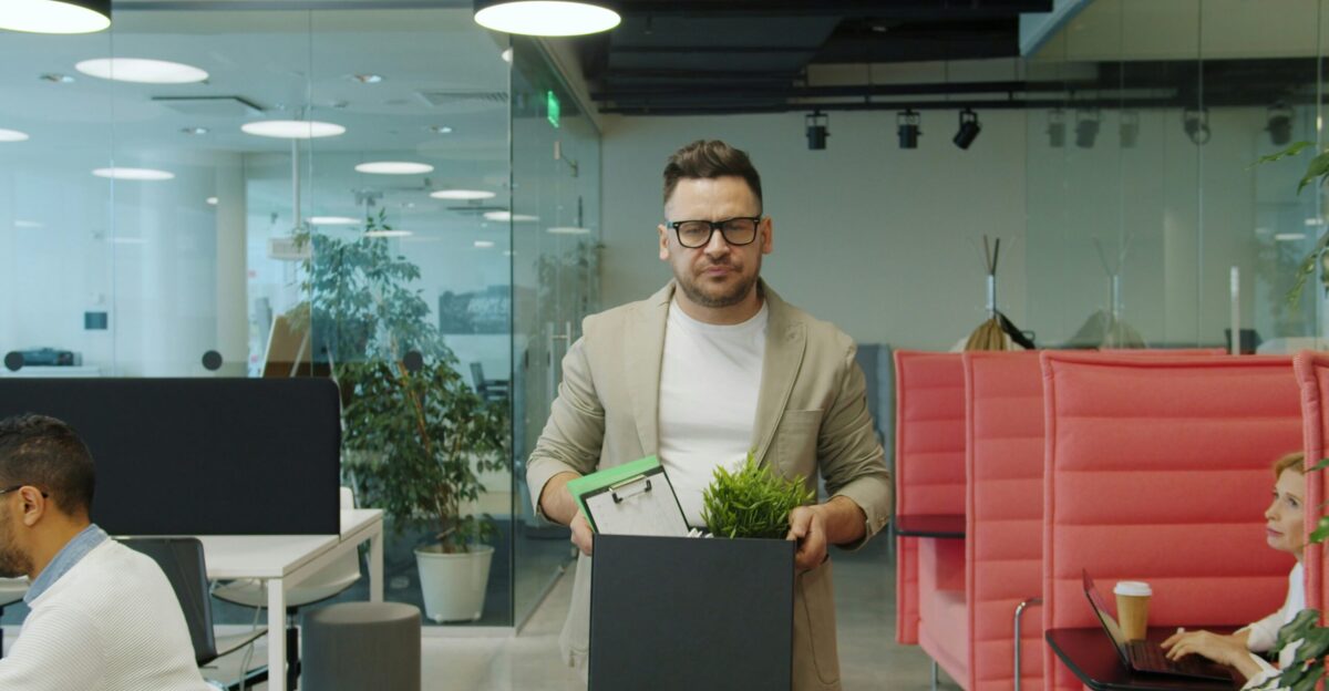 Man carrying box of belongings in office