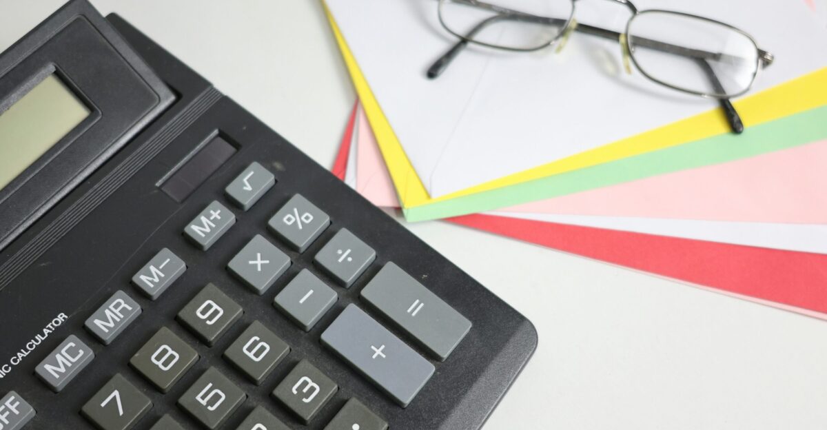 Calculator and glasses on colorful papers