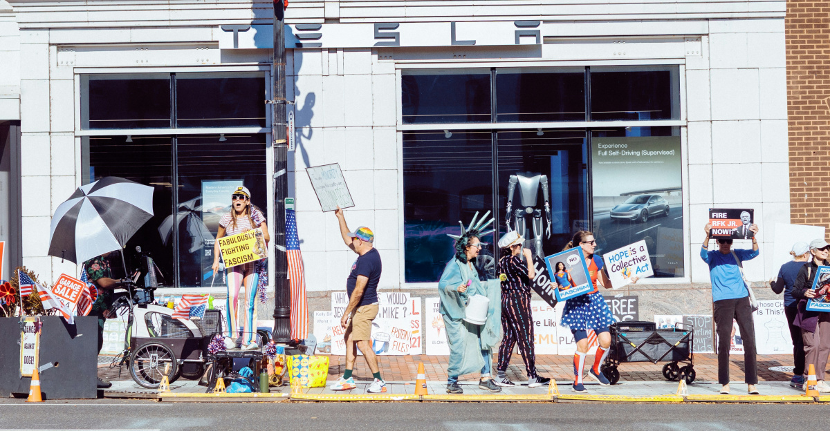 People protest on a city street with signs.