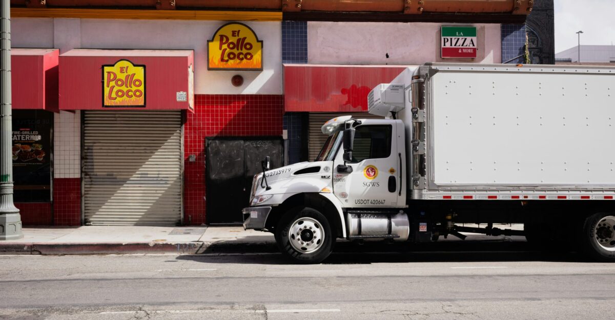 White truck parked on city street near businesses