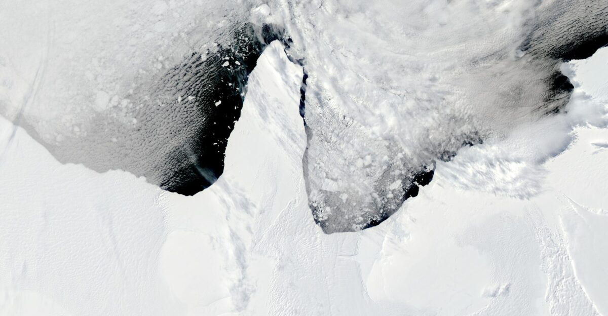 Within a 24-hour space an area of sea ice larger than the state of Rhode Island broke away from the Ronne-Filchner Ice Shelf and shattered into many smaller pieces The Moderate Resolution Imaging Spectroradiometer MODIS on NASA s Aqua and Terra satellites captured this event in this series of photo-like images from January 12 and January 13 2010 The long narrow tongue of ice is a bridge of sea ice linking the A-23A iceberg to the Ronne-Filchner Ice Shelf in West Antarctica The ice bridge is fast ice or sea ice that does not move because it is anchored to the shore Compared to an ice shelf the sea ice is a thin shell of ice over the ocean The difference in thickness is visible in the images The taller thicker Ronne-Filchner Ice Shelf casts a visible shadow on the ice bridge made of sea ice This particular ice bridge breaks up and reforms regularly Even though the images show a routine event they provide a spectacular view of the sometimes dramatic arrival of summer in the Polar South