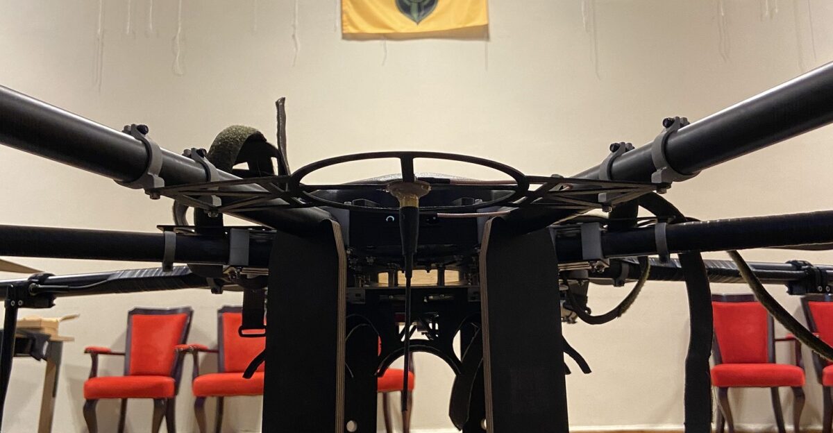 R18 drone on the exhibition at the show of the Sky Coordinator film in honor of Volodymyr Kochetkov-Sukach Organized by Aerorozvidka The Aerorozvidka flag hangs on the wall