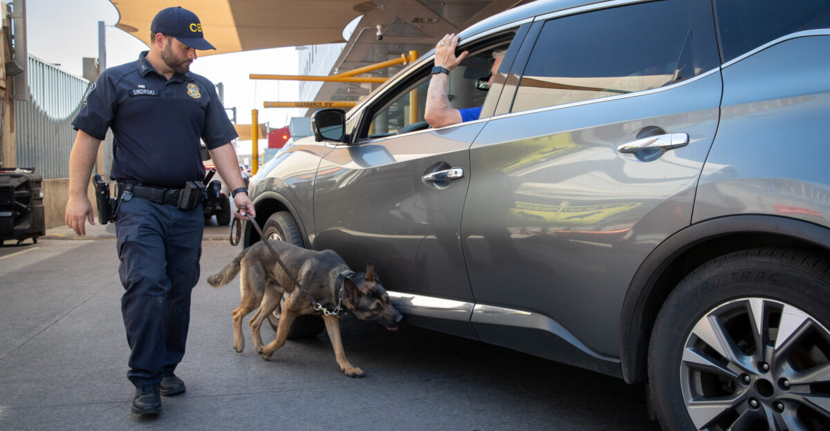 A U S Customs and Border Protection officer and his K-9 inspect a vehicle arriving at the Port of DeConcini in Nogales Arizona June 12 2024 CBP photo by Jerry Glaser
