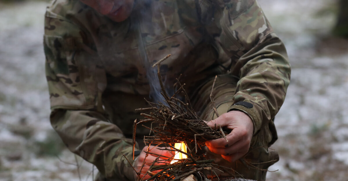 Instructor from the U K Land Warfare Center demonstrates a method for building a fire from items found in the environment for U K Troops from NATO enhanced Forward Presence Battle Group Poland during a cold weather operator s course Dec 11 2020 at Bemowo Piskie Training Area Poland U S Army photo by Staff Sgt Elizabeth O Bryson